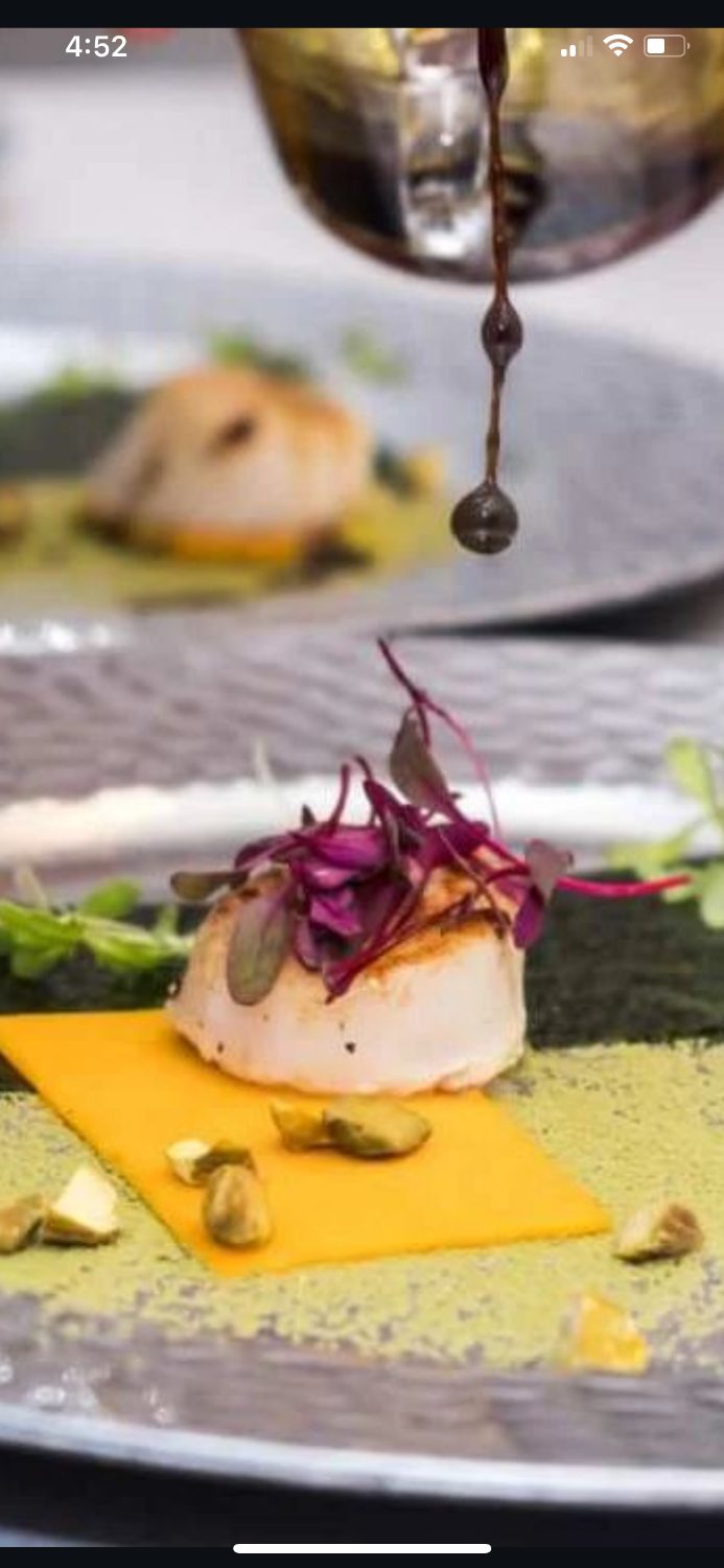 Sauce poured over a seared scallop